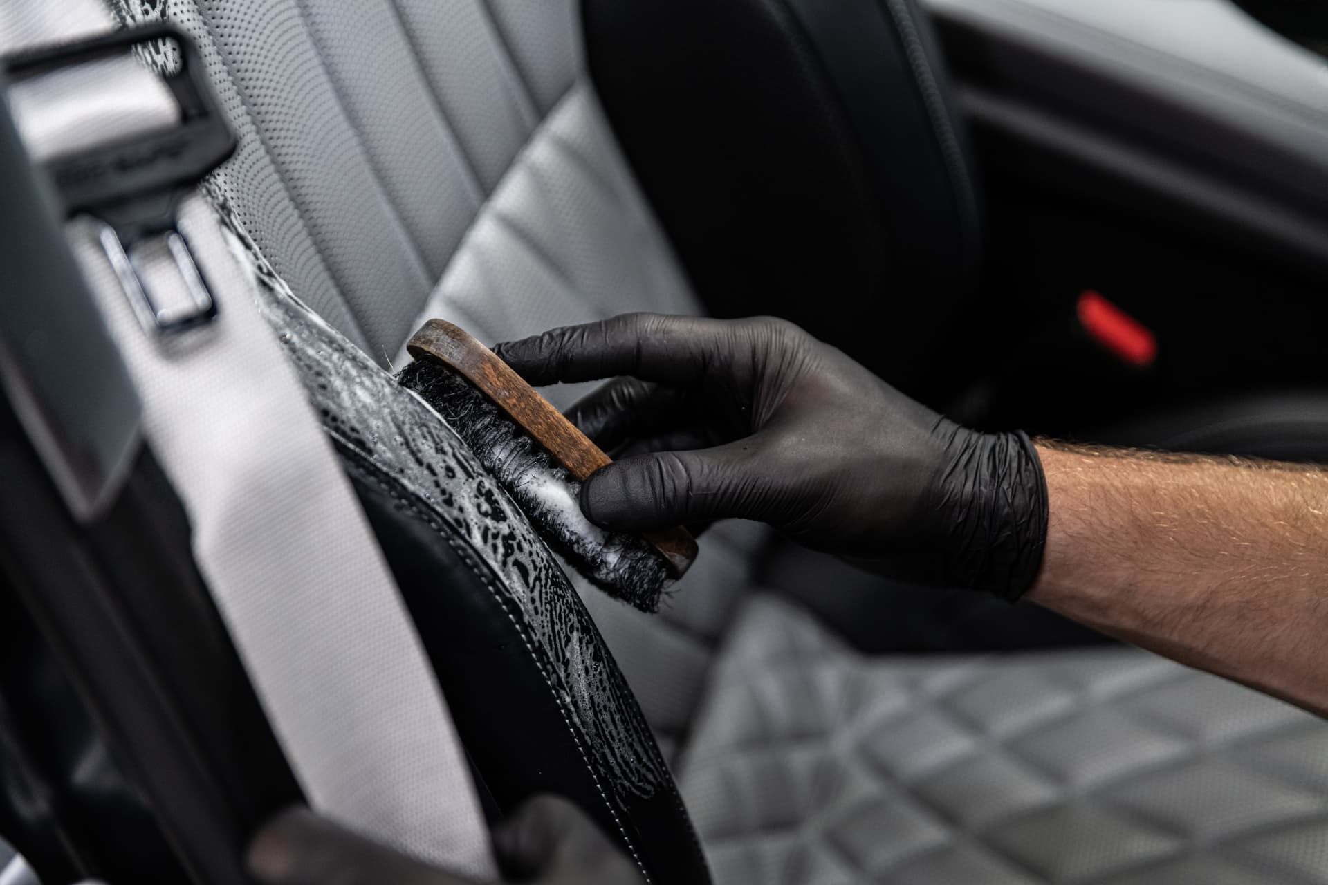 Detailreinigung der Sitznaht mit Pinsel und Schaum